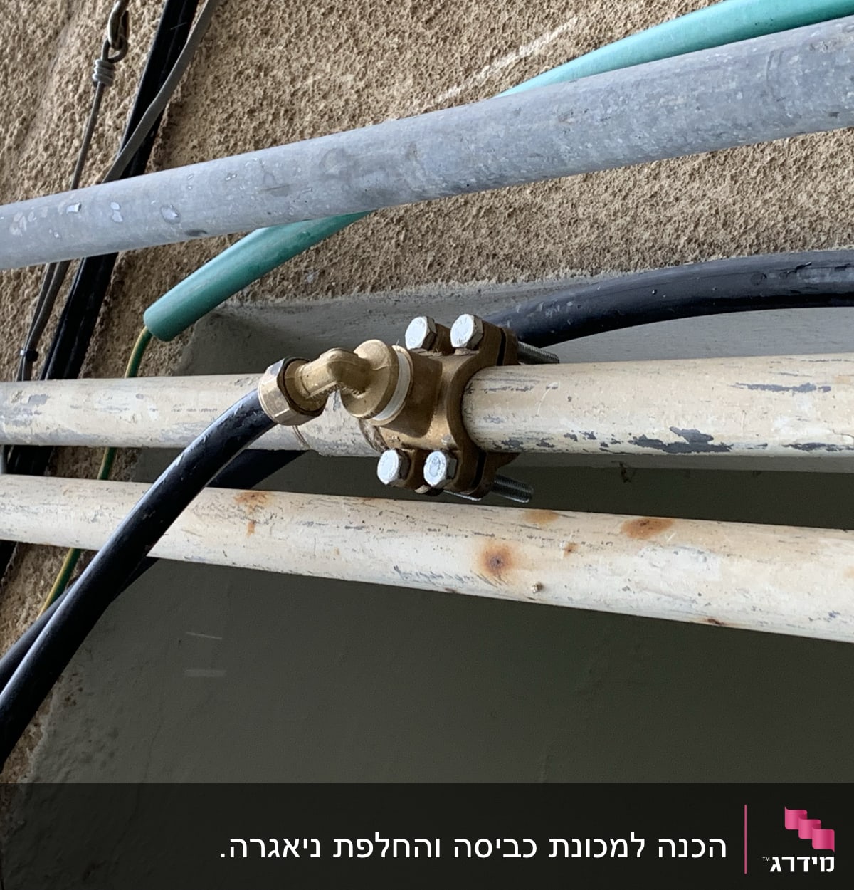 צינורות מתכת עם חיבורי ברזים על קיר